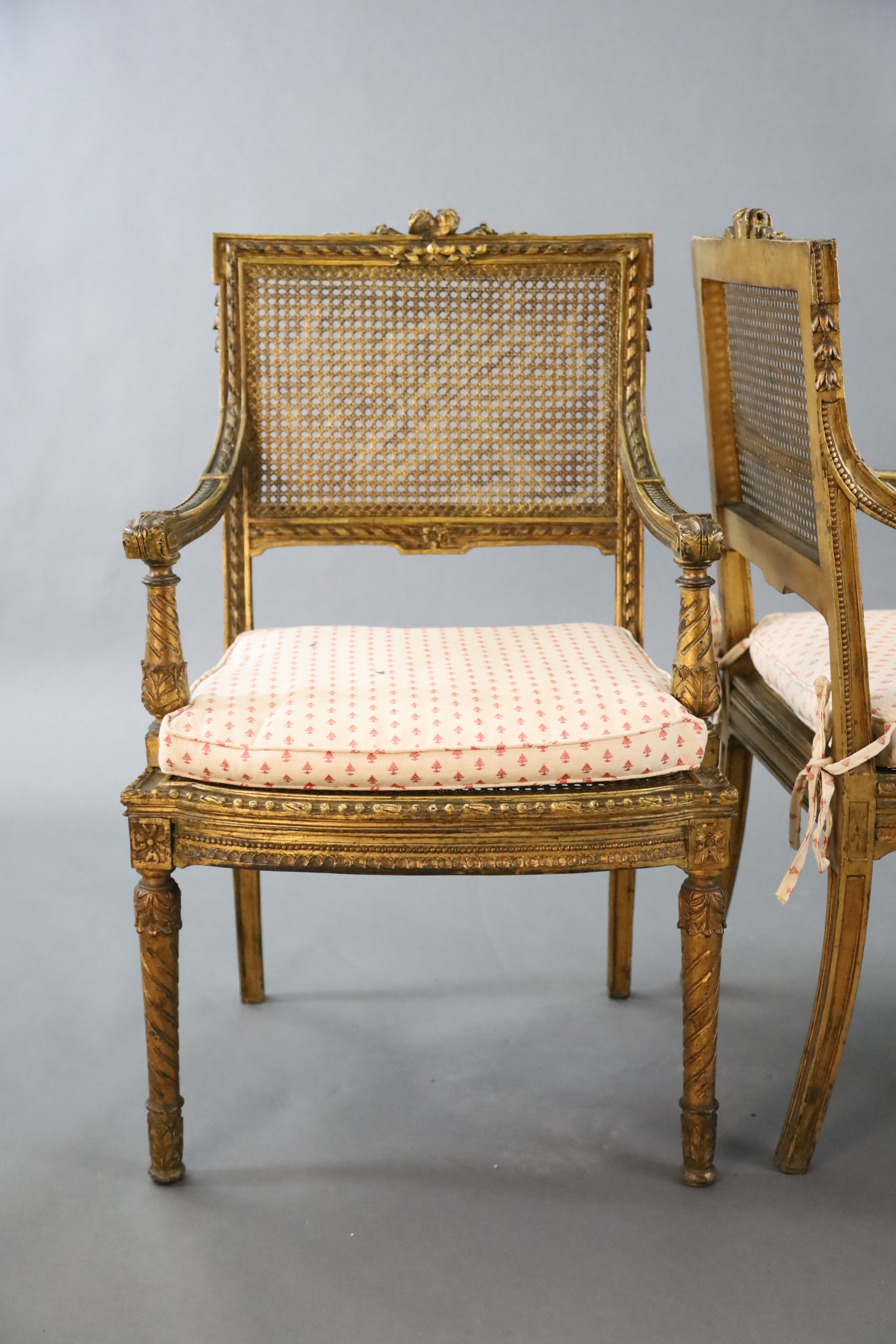 A pair of Louis XVI style walnut giltwood fauteuils, W.1ft 10in. D.1ft 9in. H.3ft 1in.